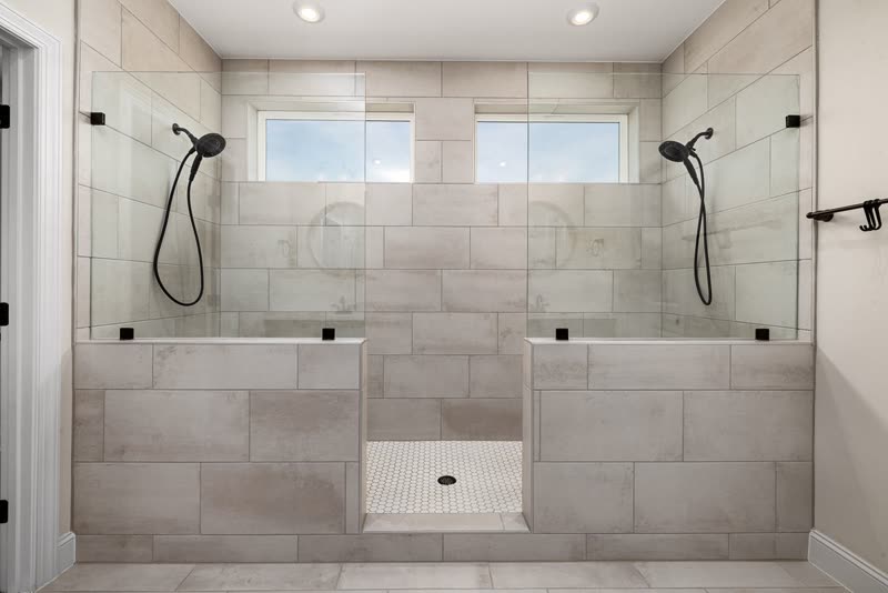 Large walk-in shower with glass panels and two shower heads